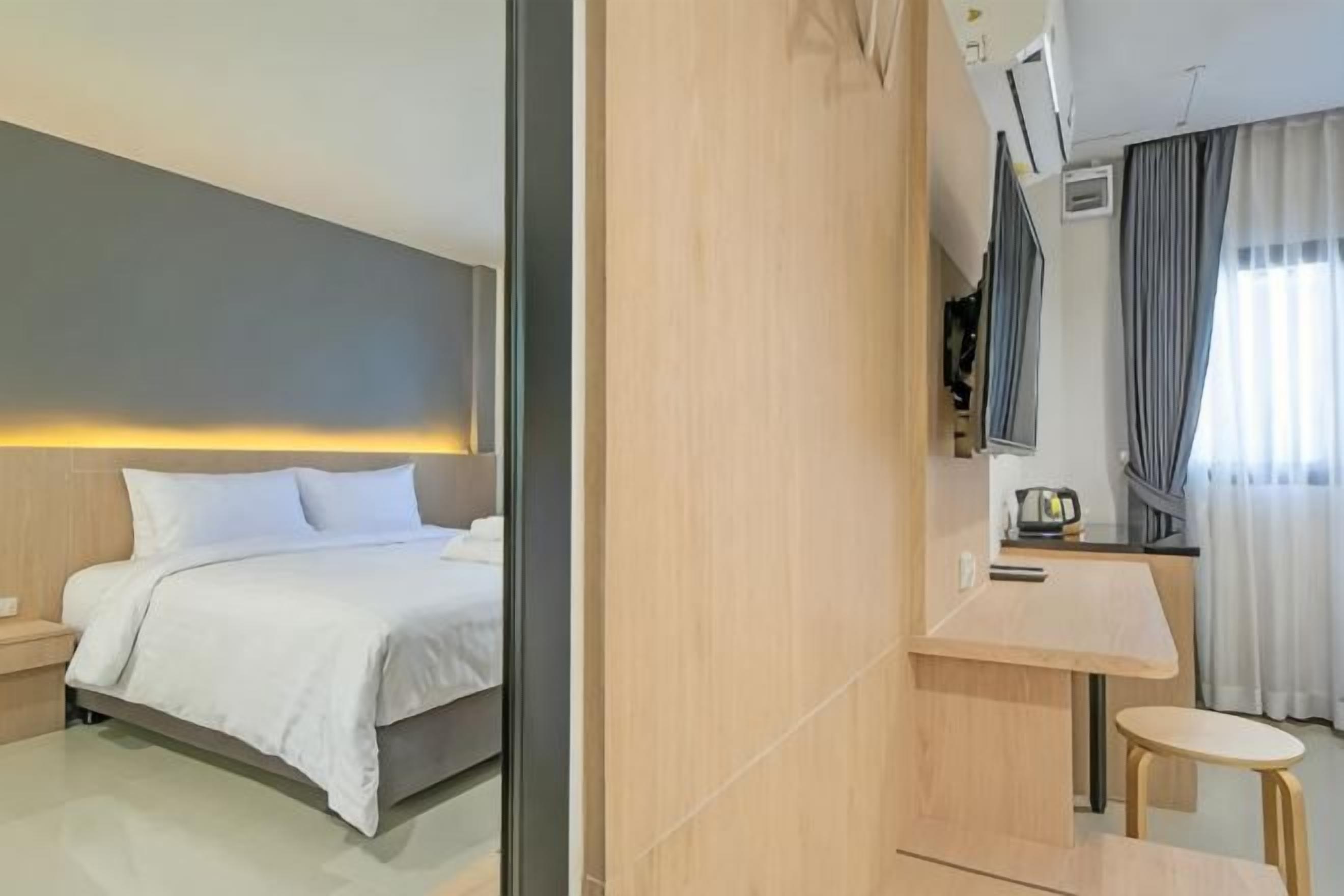 Quarto de hotel moderno com cama, mesa de cabeceira, luminária e vista para a cidade.