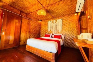 A wooden room with a bed, a table, and a hanging light fixture.