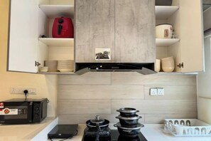 A kitchen with a built-in microwave, a red kettle, and a range hood above the stove. - Gathering l Wedding House l 18PaxTaman Oug KL (Kuala Lumpur)
