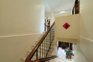 A staircase with a wooden handrail leading to a landing with a red decorative element. - Gathering l Wedding House l 18PaxTaman Oug KL (Kuala Lumpur)