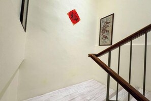 Una escalera con barandilla de madera y pared blanca.