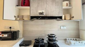 A kitchen with a microwave, toaster, and stacked pots on the counter. - Gathering l Wedding House l 18PaxTaman Oug KL (Kuala Lumpur)