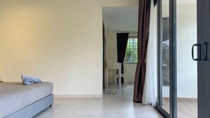 A bedroom with a bed, a small table, and a chair in the background. - Gathering l Wedding House l 18PaxTaman Oug KL (Kuala Lumpur)