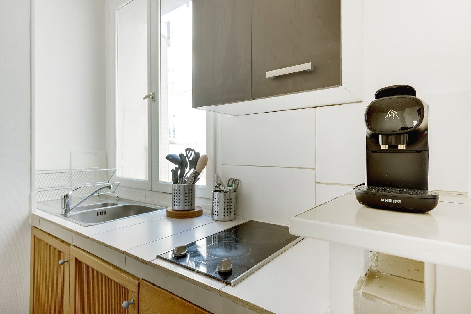 Une cuisine moderne équipée d’un évier, d’une cuisinière et d’une machine à café.