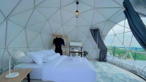 A modern, geometric-designed tent with a bed, a table, and a view of the landscape. - Sky Bay Chiangkhan (Chiang Khan)