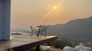 Un espace extérieur aménagé avec une table et des chaises, offrant une vue sur un paysage pittoresque.