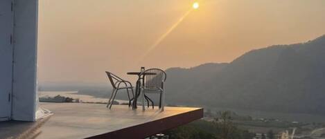 Un espace extérieur aménagé avec une table et des chaises, offrant une vue sur un paysage pittoresque.