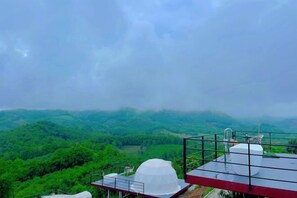 A view of a green landscape with a building featuring a white dome and a red structure. - Sky Bay Chiangkhan (Chiang Khan)