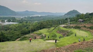 A golf course with multiple players, surrounded by lush greenery and distant hills. - Sky Bay Chiangkhan (Chiang Khan)
