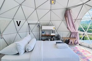 A tented accommodation with a bed, a table, and a view of the outdoors. - Sky Bay Chiangkhan (Chiang Khan)