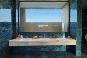 A bathroom with a large mirror, two sinks, and marble countertops.