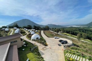 A view of dome-shaped buildings, a parking area, and a mountainous landscape.