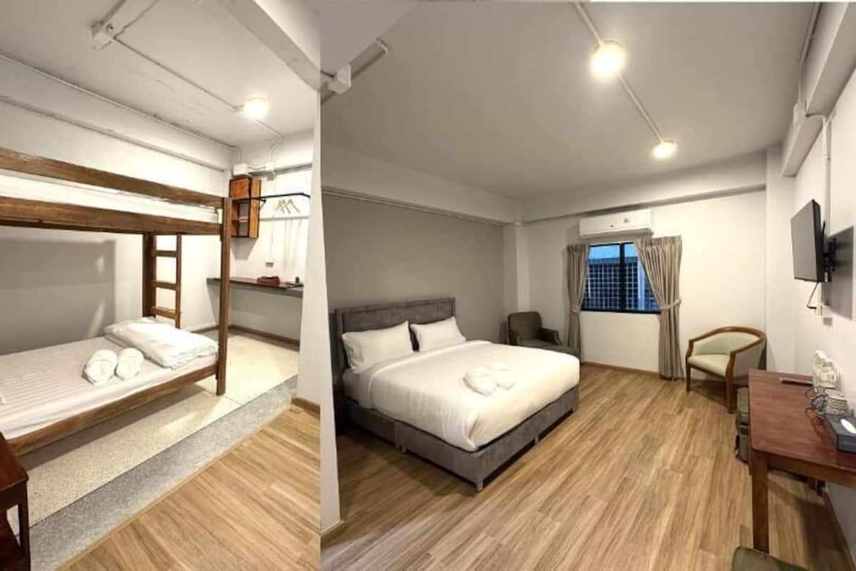 Une chambre avec un lit superposé, un lit simple, un bureau et une télévision.