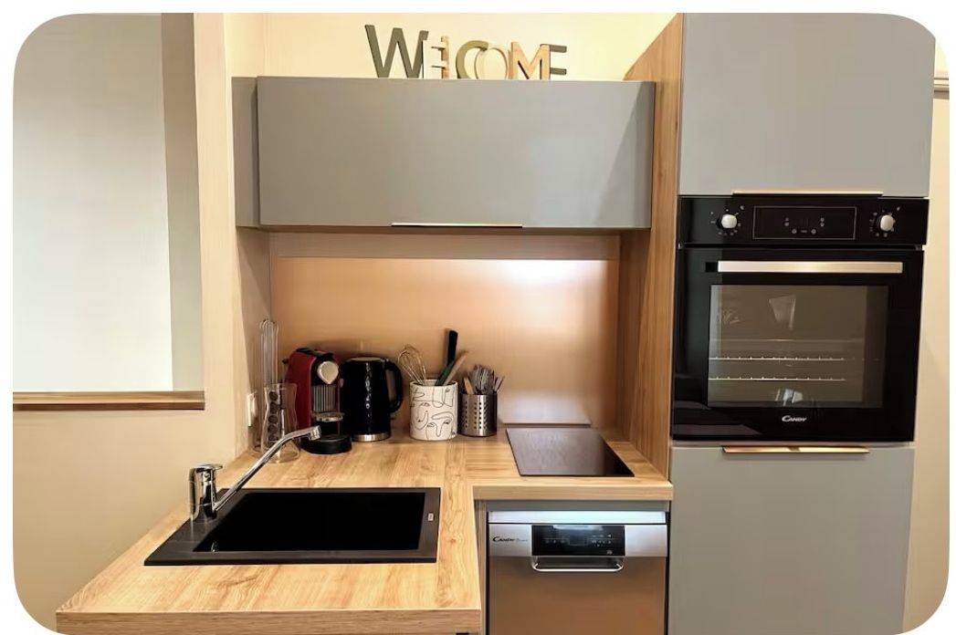 A modern kitchen with a built-in oven, a dishwasher, and a wooden countertop.