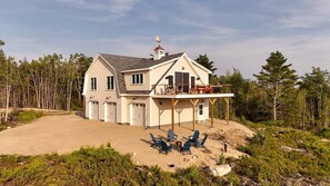 A two-story house with a covered porch and outdoor seating area. - Cadillac Vista -views of Acadia! (Gouldsboro)