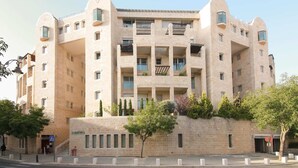 A multi-story building with balconies, a stone facade, and a pedestrian entrance. - Washington XII - Three Bedroom Apartment, Sleeps 7 (Jerusalem)