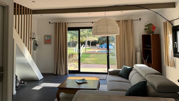 A modern living room with a sofa, coffee table, and a staircase leading to another level. - CASITA LATINA - Adults Only (Saint Genis des Fontaines)