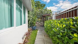 A pathway leading to a house with a white exterior, a green lawn, and a wooden fence. - 7bl-piccioni in San Juan (San Juan)