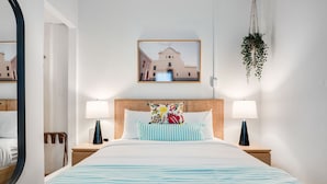 A hotel room with a bed, two bedside tables, a hanging plant, and a framed picture on the wall. - 7bl-piccioni in San Juan (San Juan)