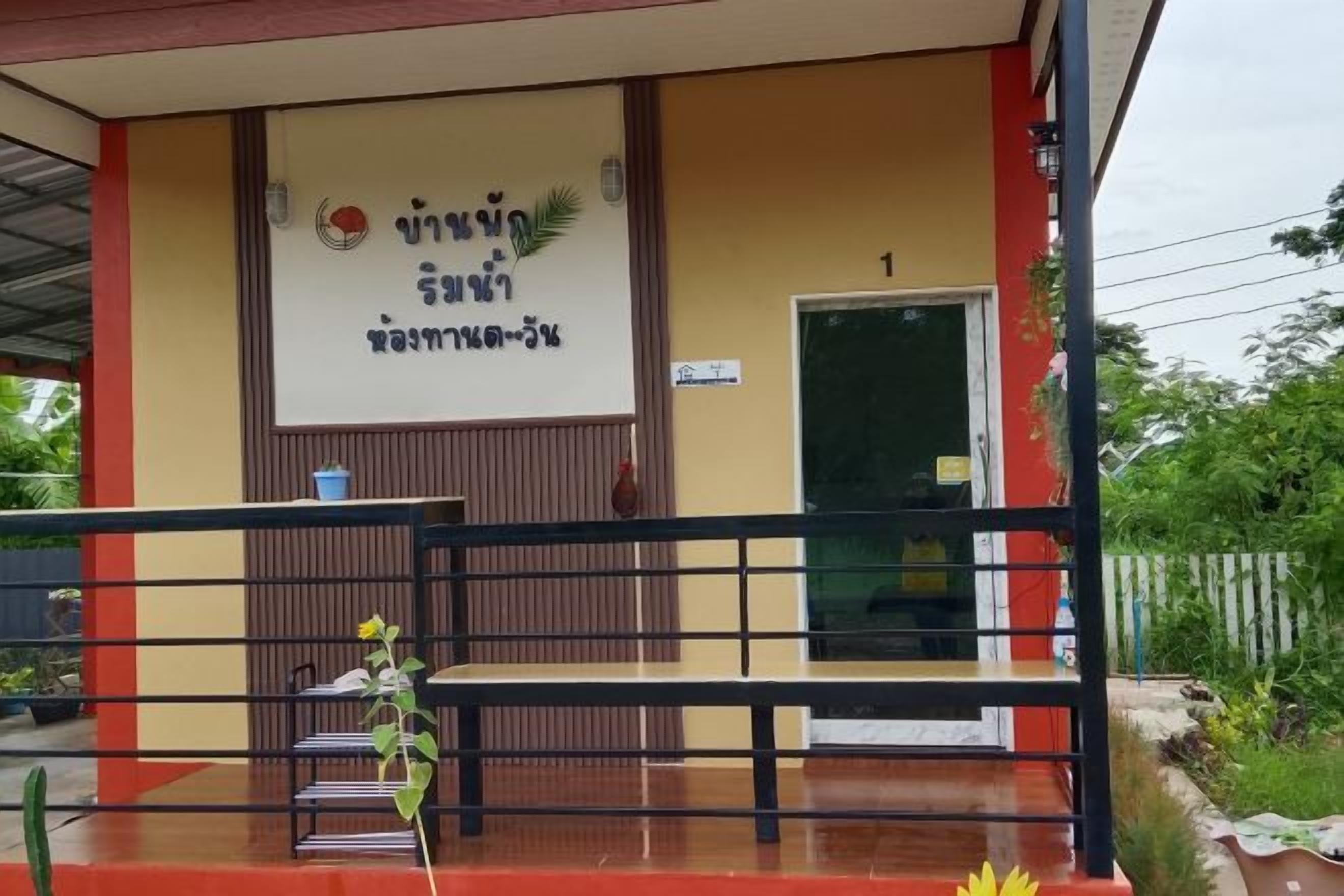 A building entrance with a sign, a bench, and a door.