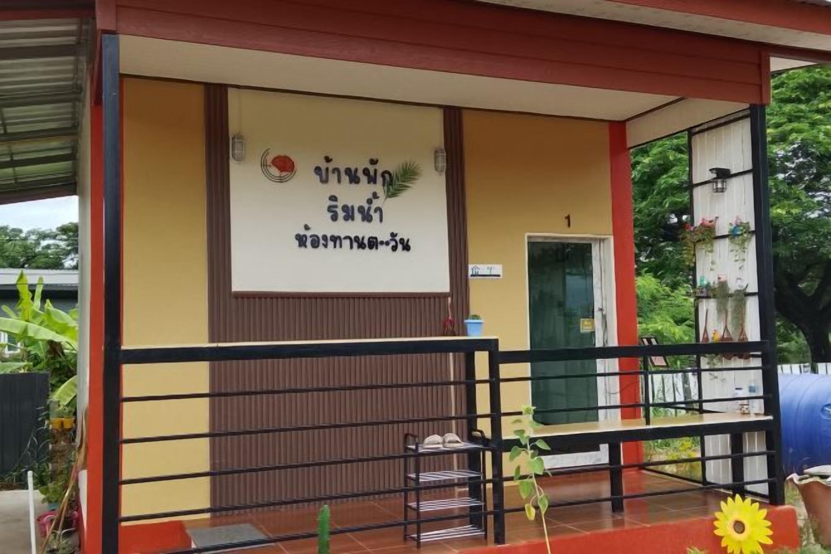A building with a signboard, a door, and a railing.