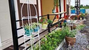 Ein Balkon mit Topfpflanzen und einem weißen Vogelkäfig.