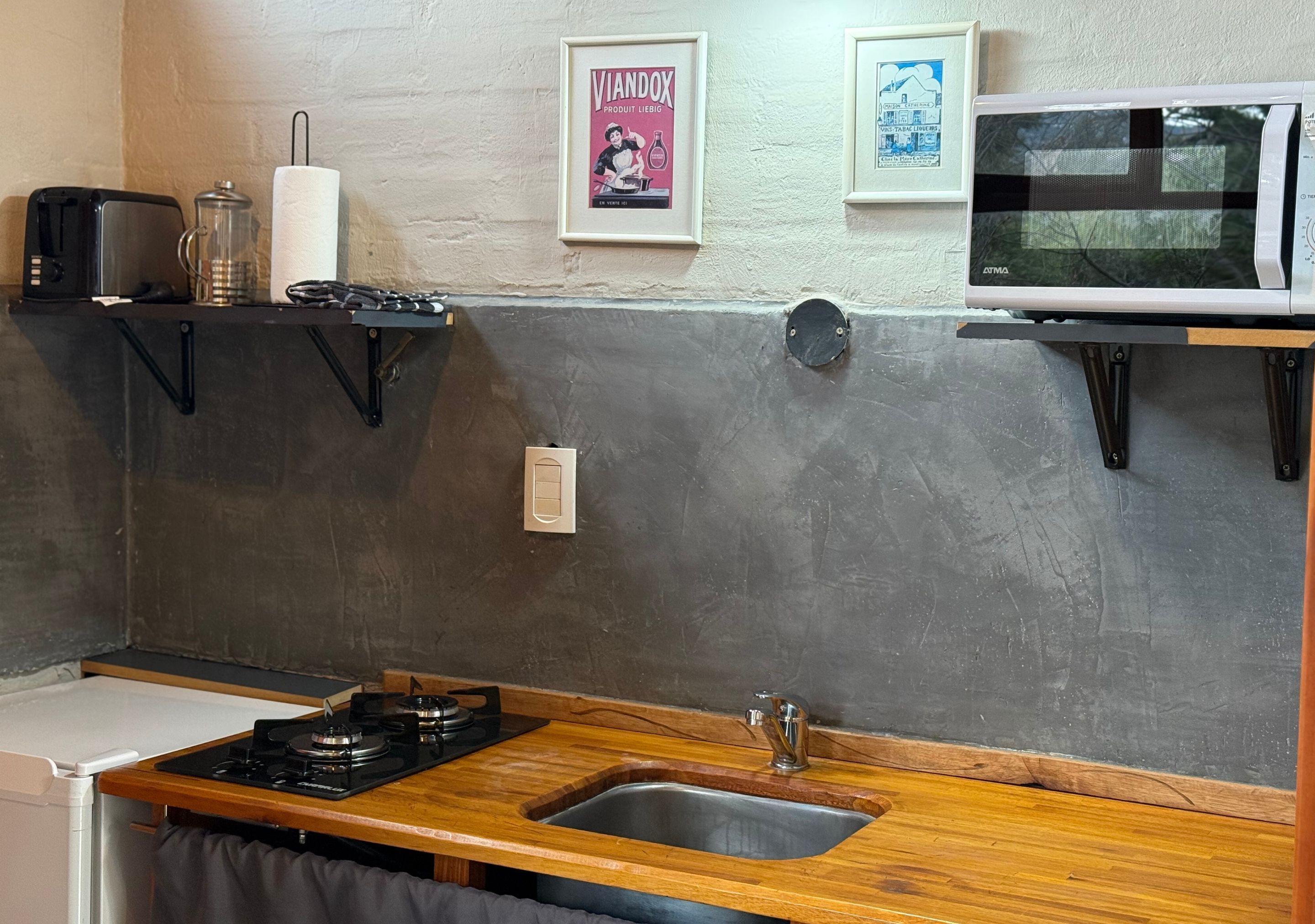A kitchen with a gas stove, a sink, a microwave, and a toaster.