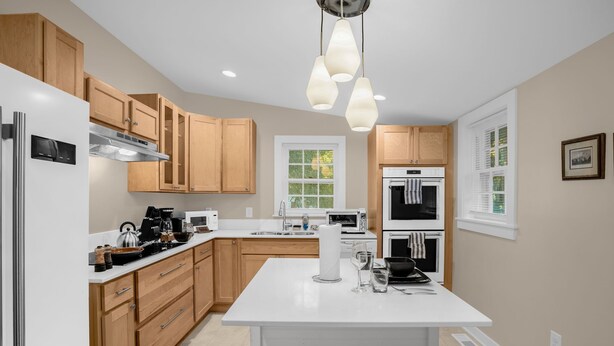 A modern kitchen with wooden cabinets, stainless steel appliances, and a central island. - Charming 3BR/2BA Sleeps 6 in Graham, NC has everything you need! (Graham)