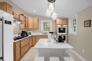 A modern kitchen with wooden cabinets, stainless steel appliances, and a central island. - Charming 3BR/2BA Sleeps 6 in Graham, NC has everything you need! (Graham)