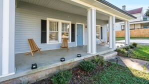 A house with a covered porch, a blue door, and a number '215' on the wall. - Charming 3BR/2BA Sleeps 6 in Graham, NC has everything you need! (Graham)