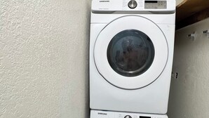 A laundry room with two stacked white Samsung washing machines.