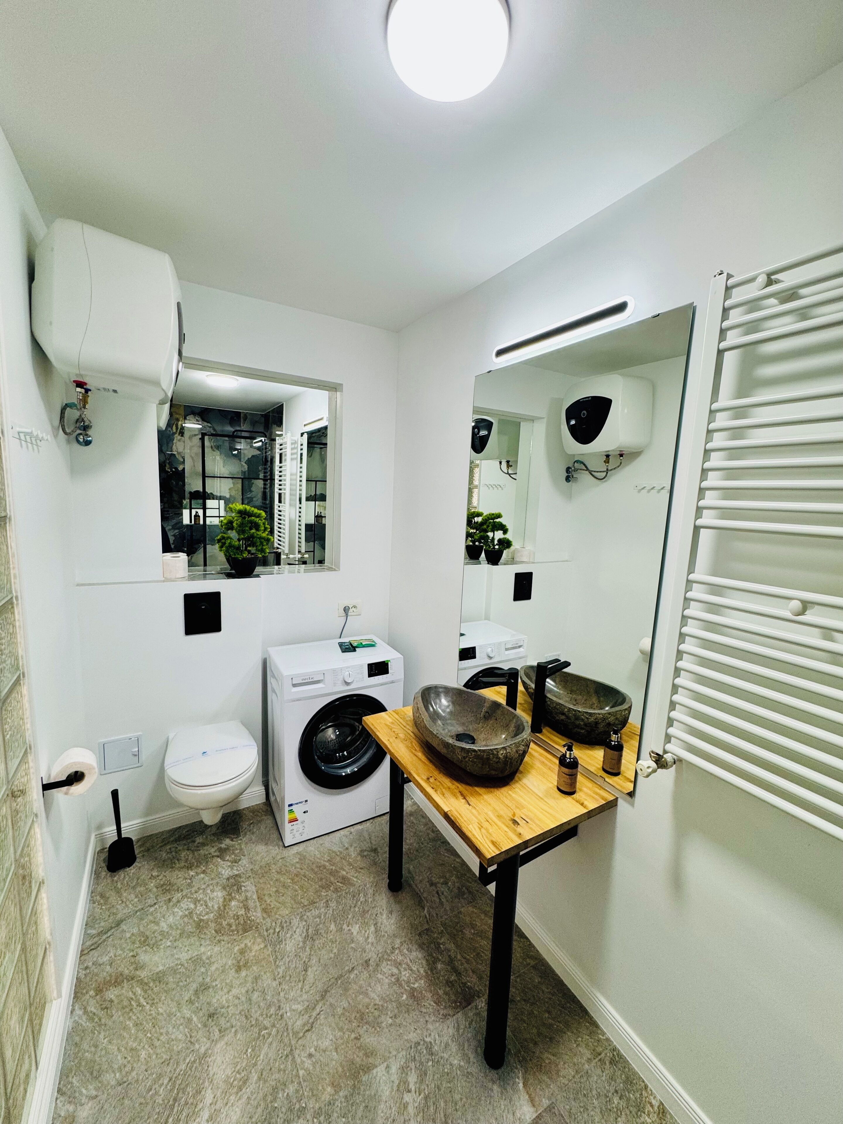 Un baño pequeño con inodoro, lavadora y lavabo.
