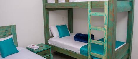 A bunk bed with two levels, each with a white mattress and teal bedding.