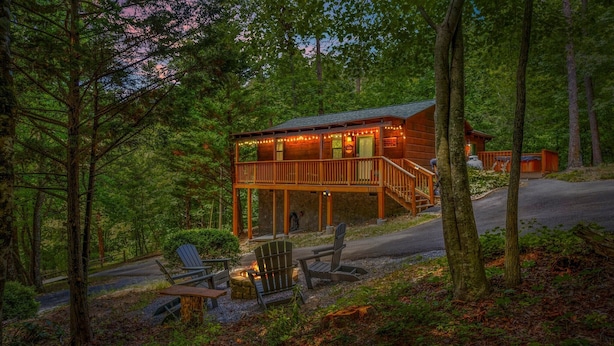 Eine Holzhütte mit Veranda, Sitzgelegenheiten im Freien und einem Feuerkorb.