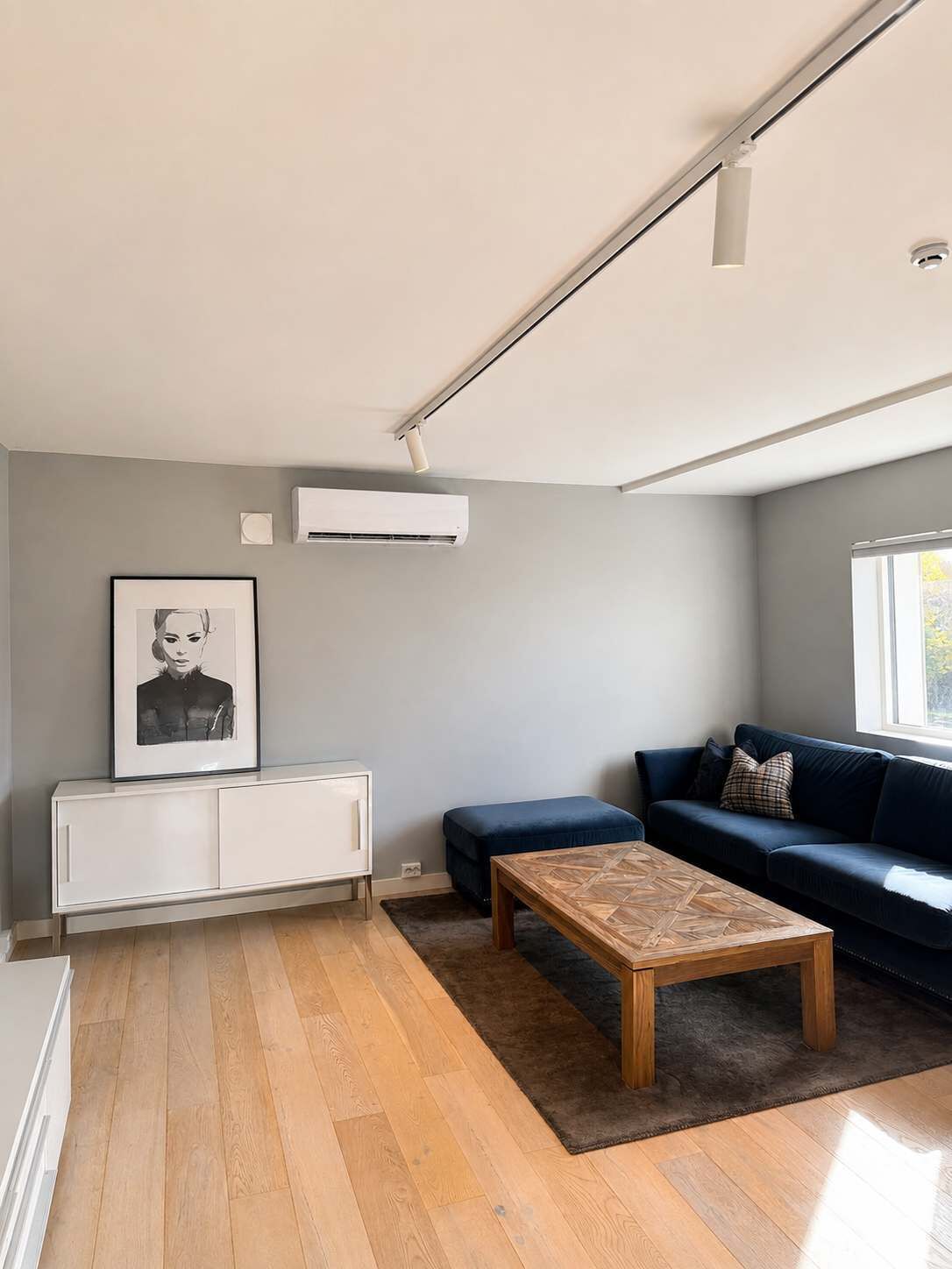 Una sala de estar moderna con un sofá, una mesa de centro y un cuadro en la pared.