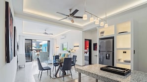 A modern kitchen with granite countertops, a built-in refrigerator, and pendant lighting. - Modern 1BR at Rizz Suites • GYM • Pool Access • Walk to Beach • King Bed• AC ew (Sosúa)
