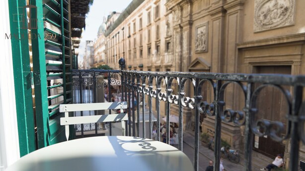 A balcony with a view of a historic building and a street below. - Maqueda 259 - In Palermo's Lively Heart (Palermo)