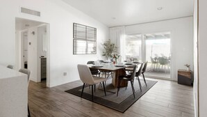A modern dining area with a wooden table, chairs, and a large window. - Chic Scottsdale Stay | Pool, Hot Tub! (Scottsdale)