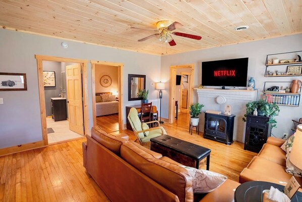 A cozy living room with a fireplace, a TV, and a bookshelf.