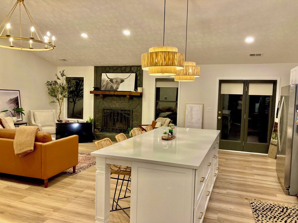 Una sala de estar moderna con una isla central, un sofá y una chimenea.