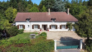 A two-story house with a red-tiled roof, white walls, and wooden shutters. - Large charming house with swimming pool, huge garden and close to state forest (Saint-Laurent)