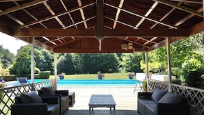 A covered outdoor area with a pool, wicker furniture, and potted plants. - Large charming house with swimming pool, huge garden and close to state forest (Saint-Laurent)