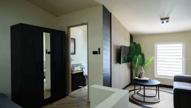 A modern living room with a large wardrobe, a round coffee table, and a sofa. - Aki Banda Suites (Willemstad)