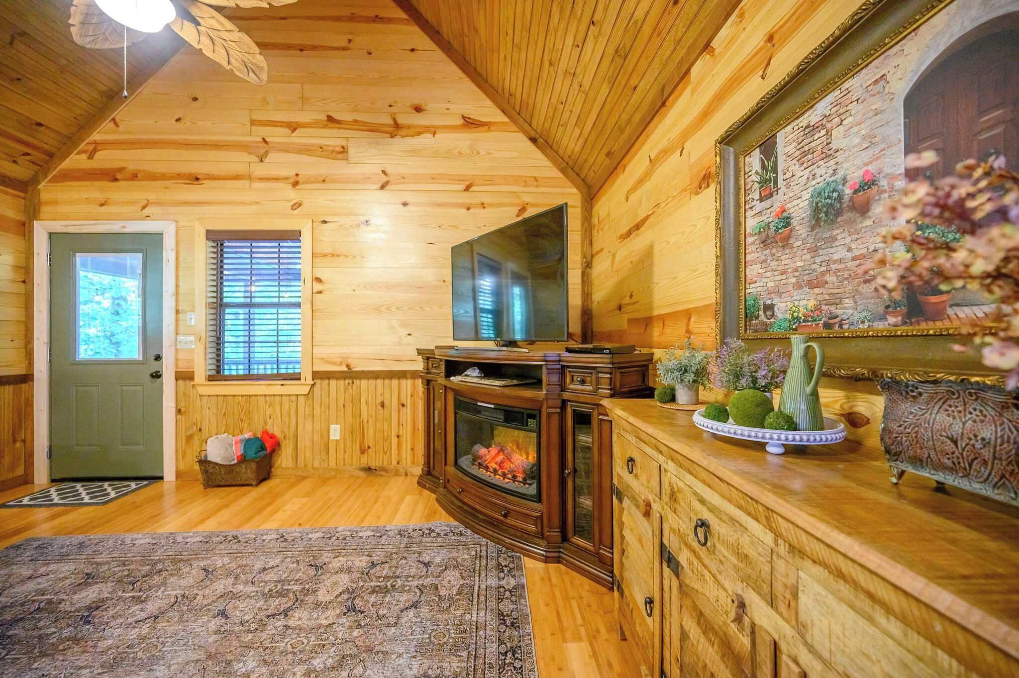 L’intérieur chaleureux d’un chalet avec des murs en bois, une cheminée, un grand miroir et un élément décoratif mural.