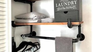 Une étagère à linge avec des serviettes pliées et une boîte étiquetée « Linge ».