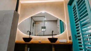 A bathroom with a large mirror, two sinks, and a teal door. - Pousada Boutique Preá Beira Mar - Raro Life (Cruz)