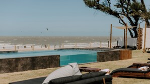 A poolside area with lounge chairs and a view of the ocean. - Pousada Boutique Preá Beira Mar - Raro Life (Cruz)