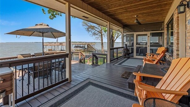 Una terraza techada con mobiliario exterior, vistas al agua y un muelle.