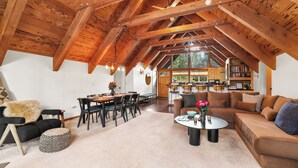 Un loft espacioso con vigas de madera a la vista, un comedor y una zona de estar acogedora con una mesa de centro.