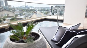 En moderne balkon med udsigt over bybilledet, inklusive en bro og bygninger.